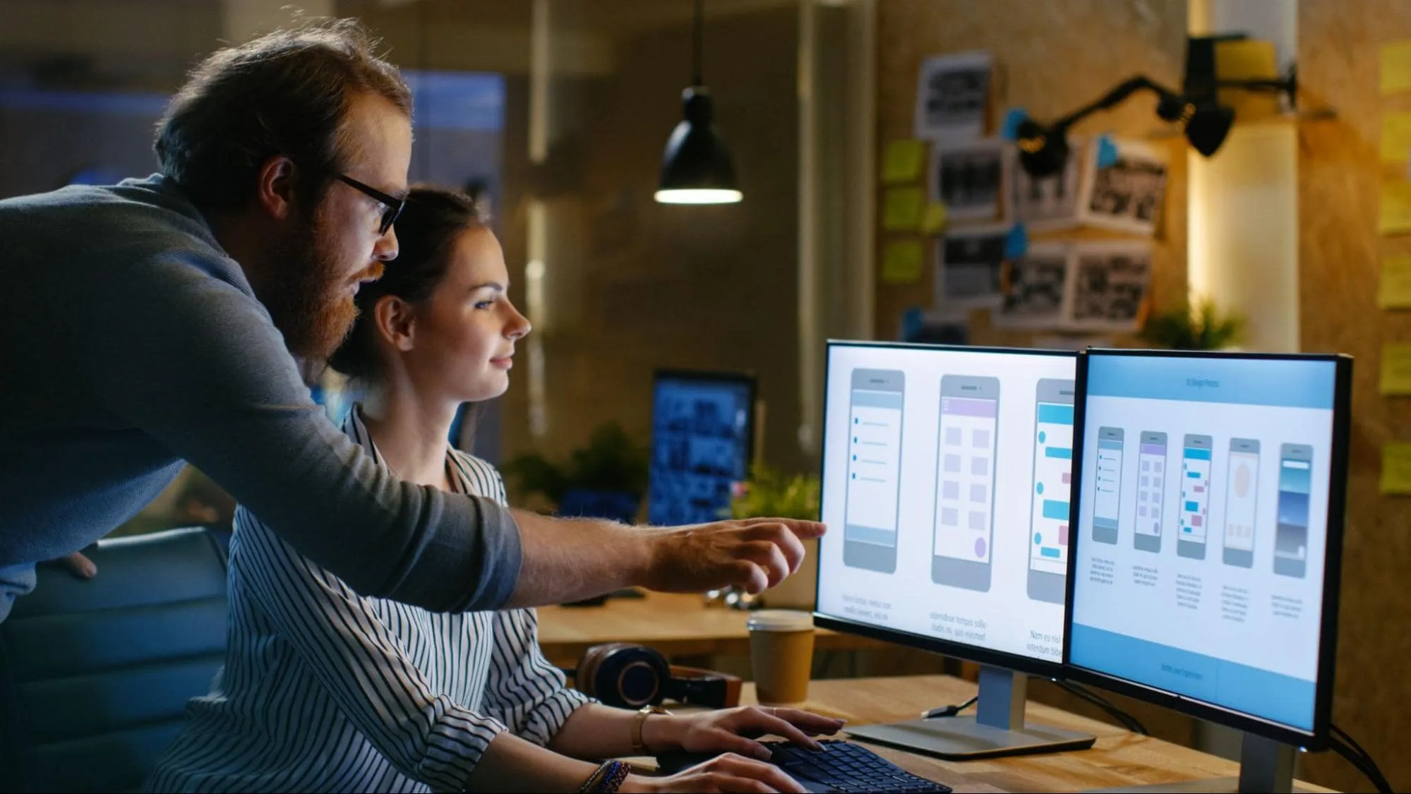 Two people looking at a screen with different mobile designs options